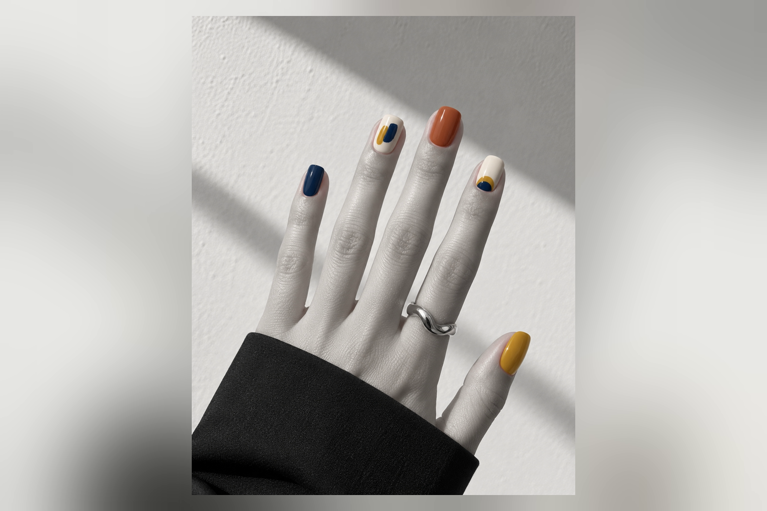 มือทำเล็บสีสันบนภาพขาวดำพร้อมแหวนเงิน